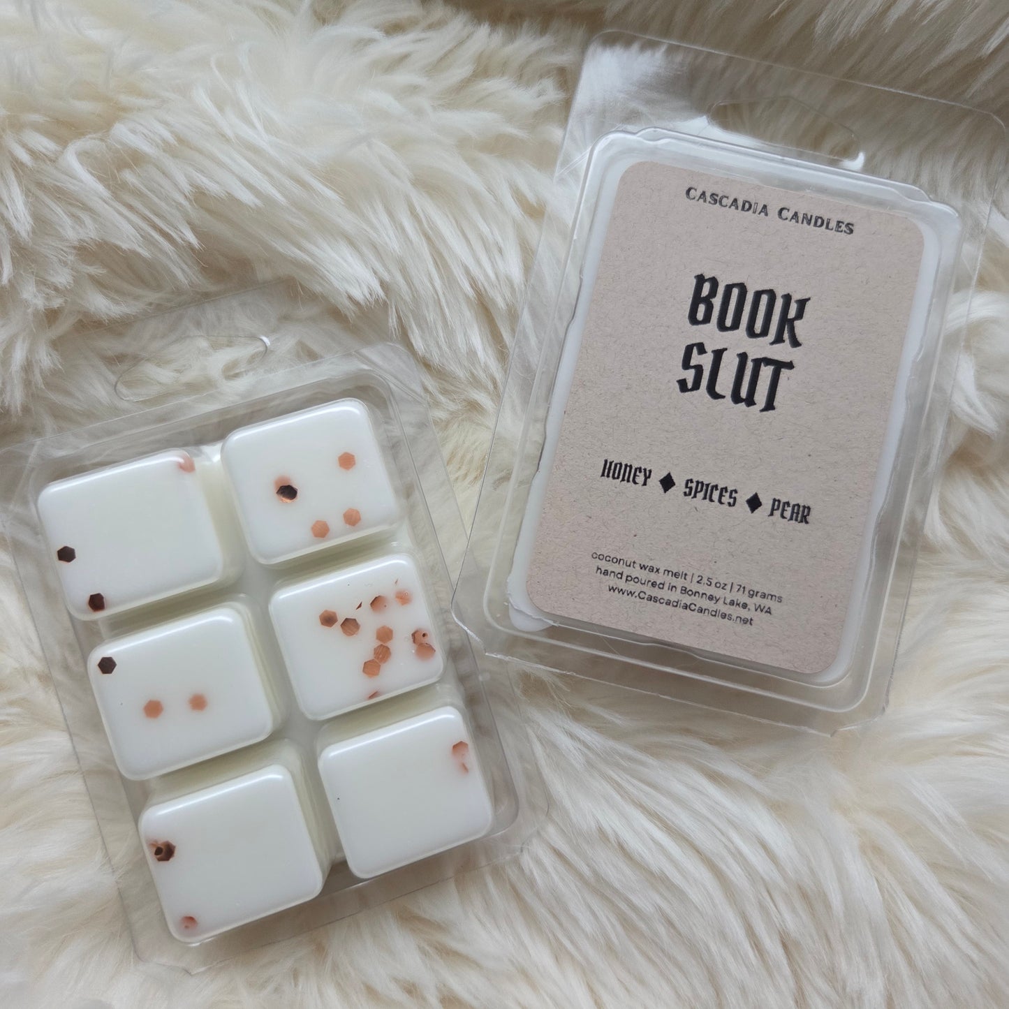 Packaged wax melts with 'Book Slut' branding on a fluffy white surface
