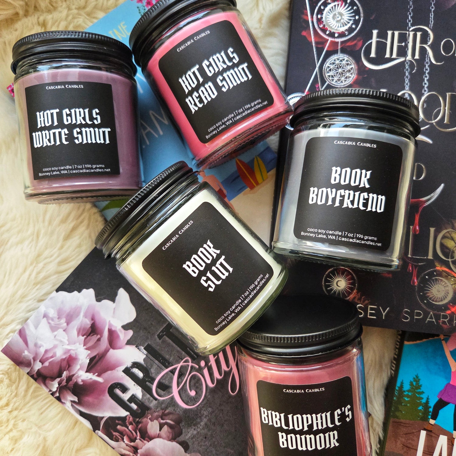 Collection of bookish candles pictured on top of a pile of books.