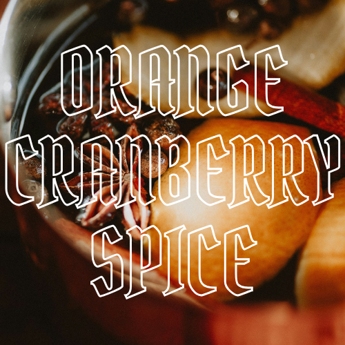 A close-up of a pot or bowl containing orange slices, cranberries, and whole spices, with large stylized text reading 'ORANGE CRANBERRY SPICE' overlaid across the center.