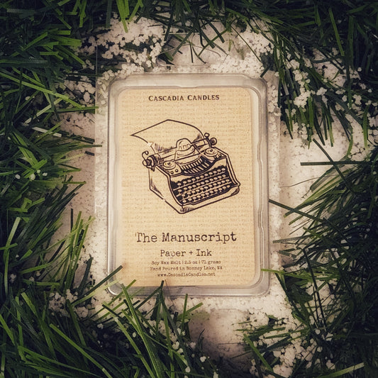 Cascadia Candles product packaging with typewriter illustration on a snowy garland background