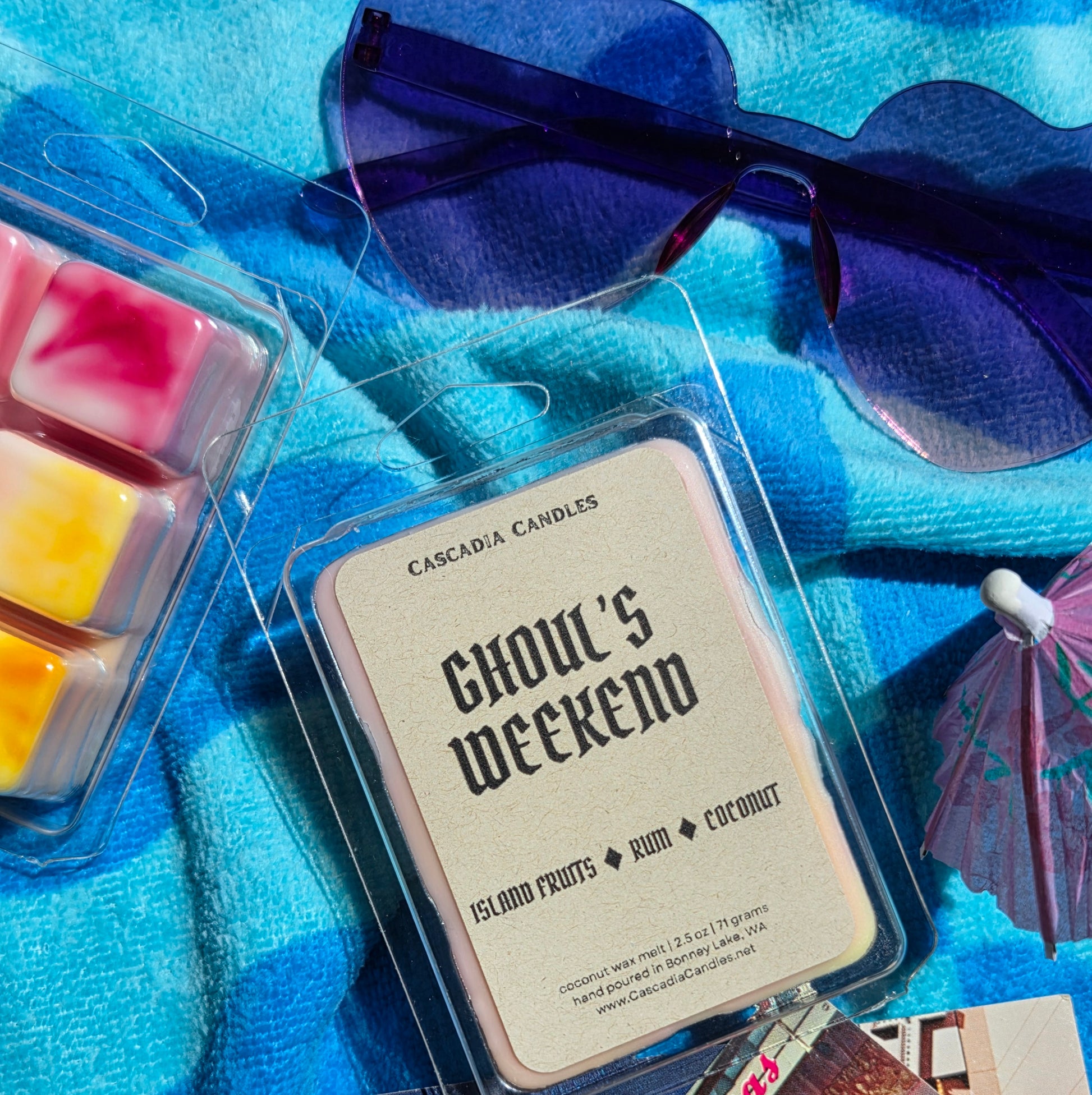 Cascadia Candles wax melts packaging with sunglasses and pink umbrella on a blue background