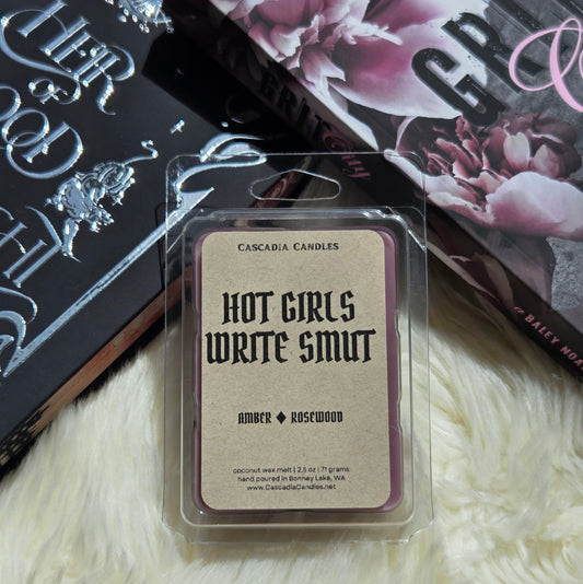 Hot Girls Write Smut clamshell propped against two romance books. 