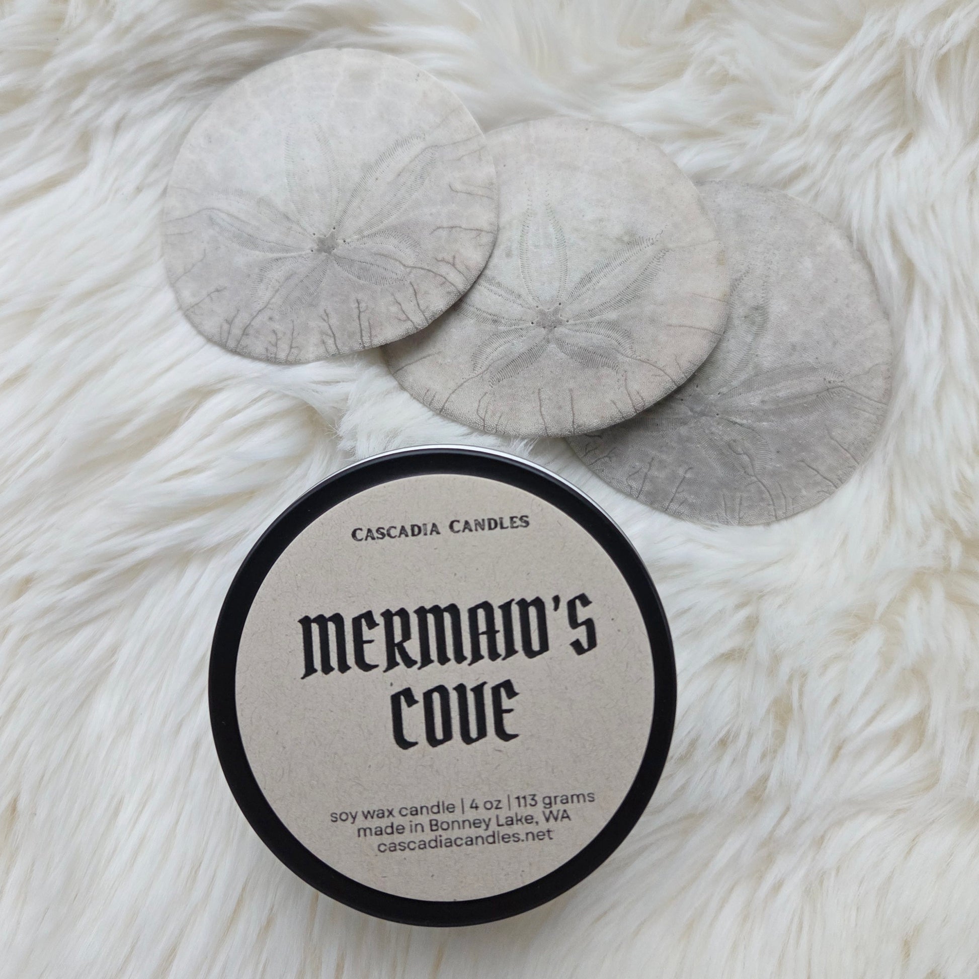 Cascadia Candles mermaid's c0ve candle on a fluffy white surface