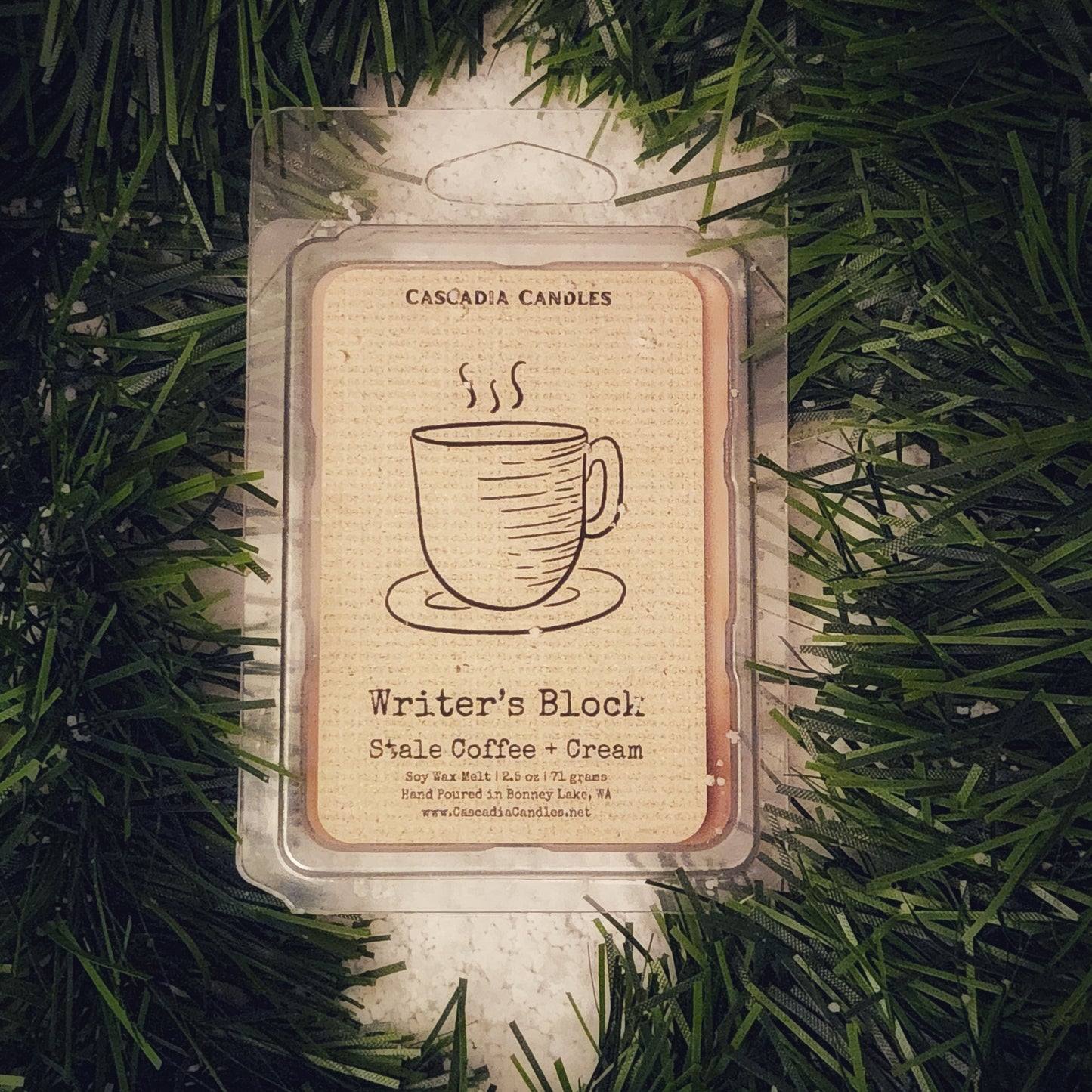 Wax melt packaging with a coffee cup design on a green garland and snow background
