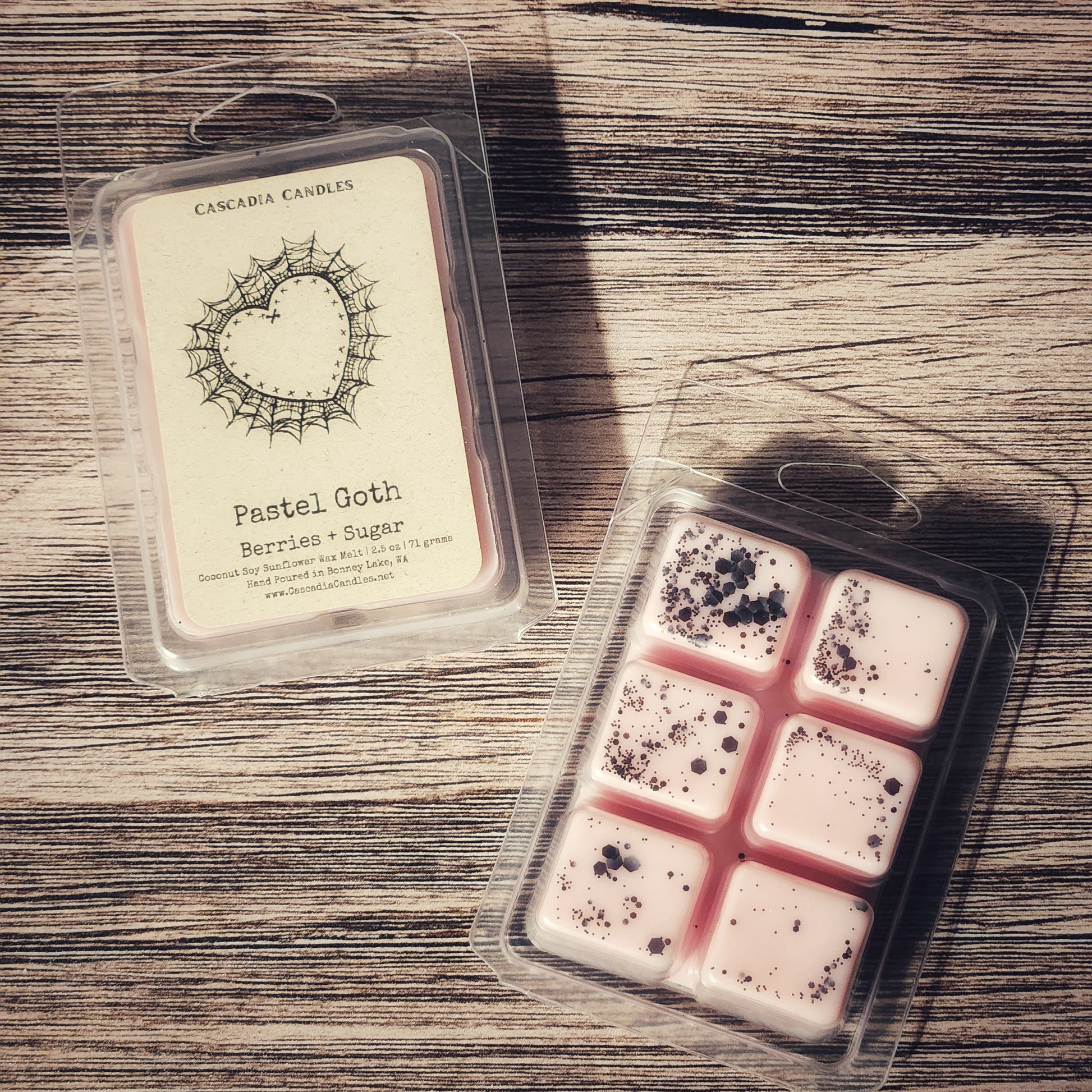 Packaged Pastel Goth wax melts with a label on a wooden surface