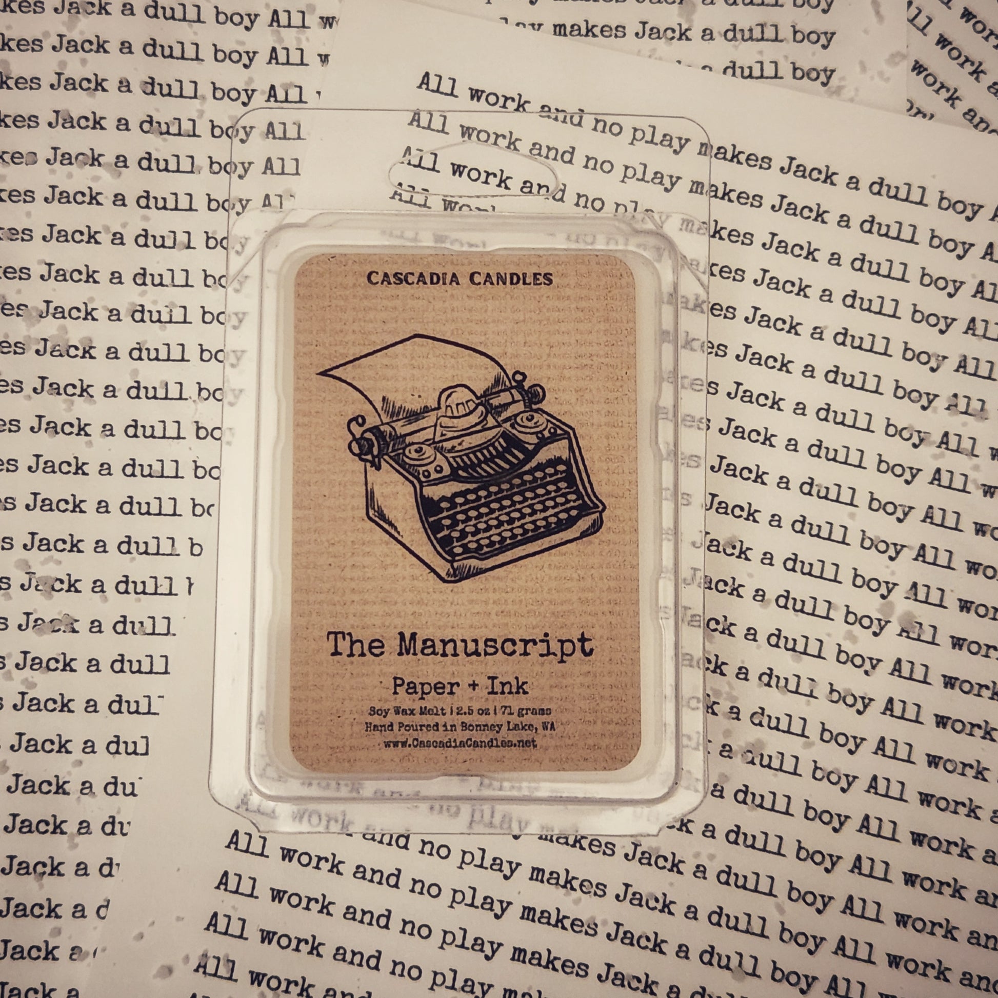 The Manuscript wax melt with typewriter illustration on a background of text.