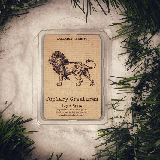 Cascadia Candles Topiary Creatures Ivy + Snow wax melt packaging with a lion illustration on a decorative background.