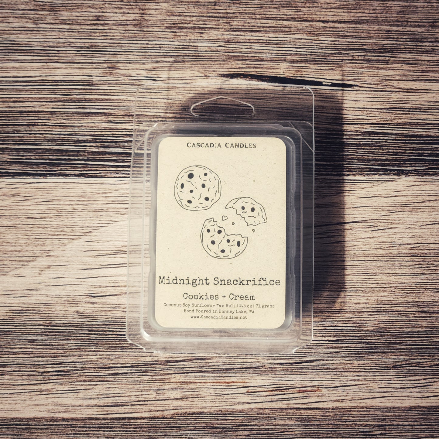 Cascadia Candles Midnight Snackrifices Cookies & Cream wax melt package on a wooden surface