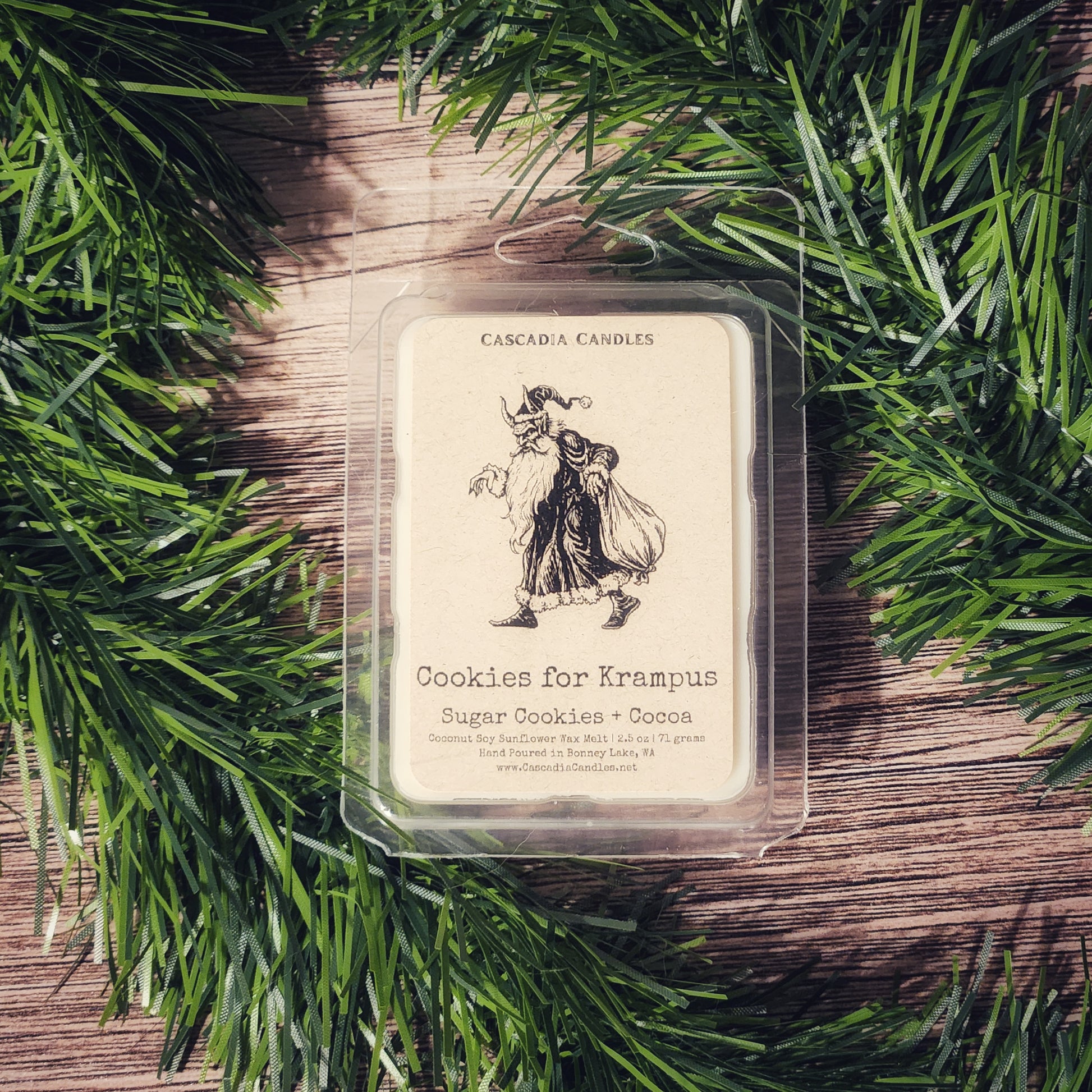 Cascadia Candles Cookies for Krampus wax melt packaging on a wooden surface with greenery