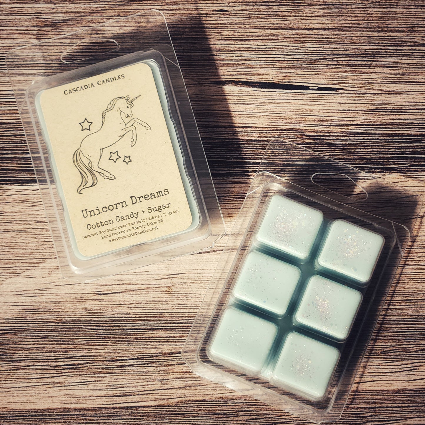 Packaged wax melts with a unicorn design on a wooden surface